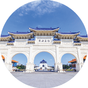 Wei e Toranlage mit drei B gen und blauen D chern vor Tempeln und dem Gedenkgeb ude im Hintergrund.