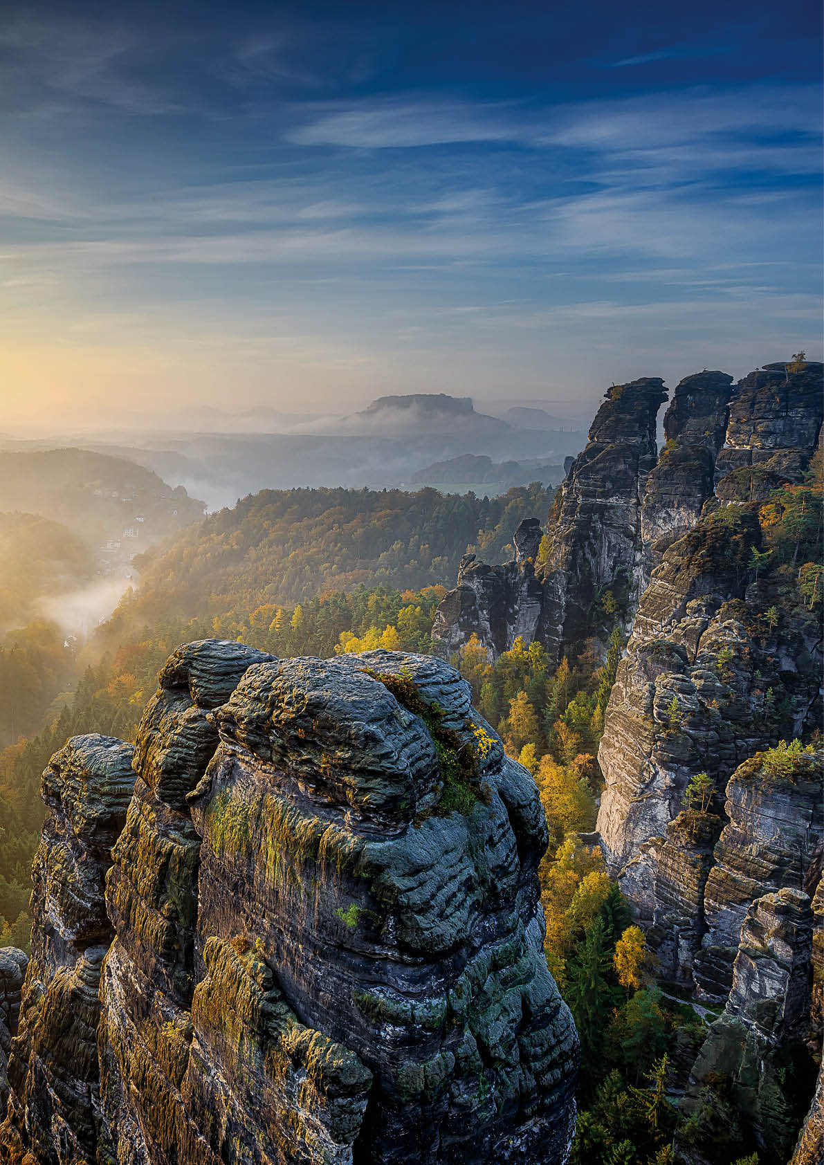 Beautiful panoramic view at sandstone rocks during foggy sunrise at Bastei, Saxon Switzerland, Germany