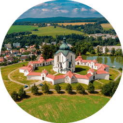 Barocke Wallfahrtskirche mit symmetrischen Geb uden auf einem grasbedeckten H gel, umgeben von Feldern und einem Teich
