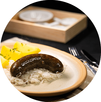 Traditionelles Gericht mit Blutwurst, Sauerkraut und Kartoffeln auf einem gedeckten Tisch