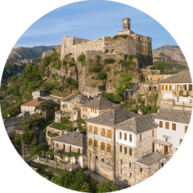 Historische Burg auf einem Felsen ber einer traditionellen Altstadt mit Stein- und Schieferd chern